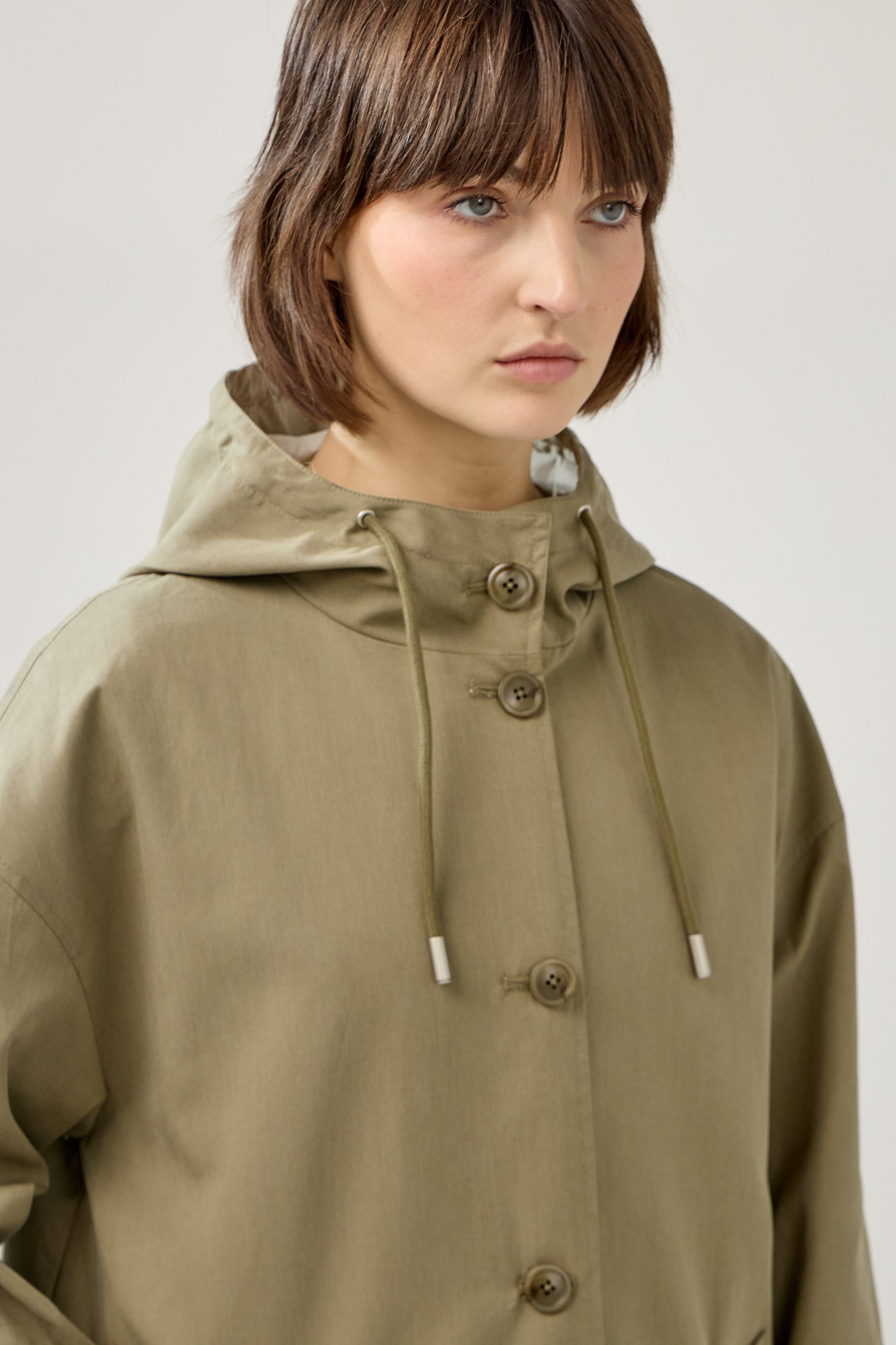 Veste longue réversible et imperméable, capuche à cordon et fermeture à boutons, poches raglans, matière déperlante, mi-saison, devant
#couleur_kaki 