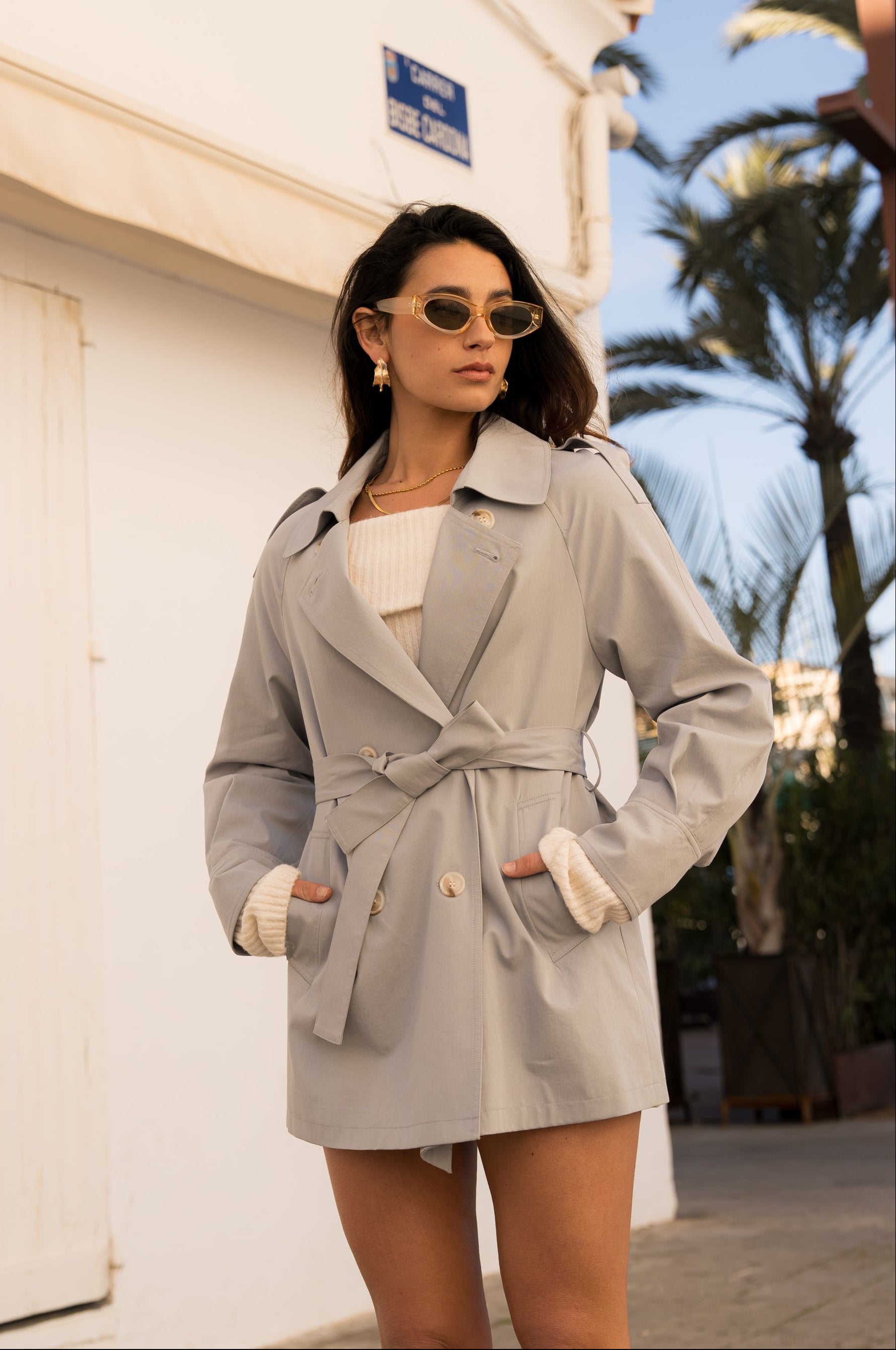 veste style trench mi-long bleu ciel, col français/à revers, boutons, pattes d'épaules, ceinture et passants, poches raglans, devant
#couleur_ciel