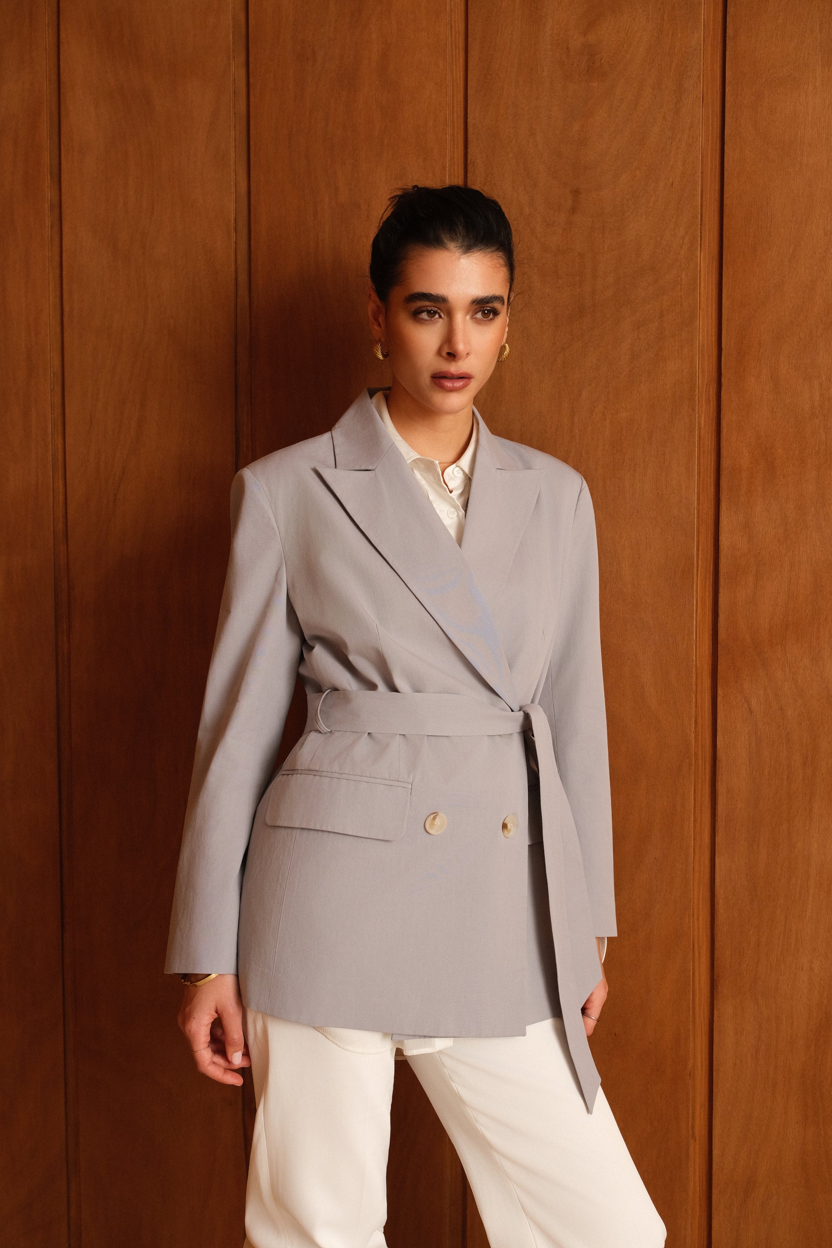 femme portant un blazer en coton bleu ciel, ceinture, boutons, col à revers, taille droit coupe élégante, devant
#couleur_ciel