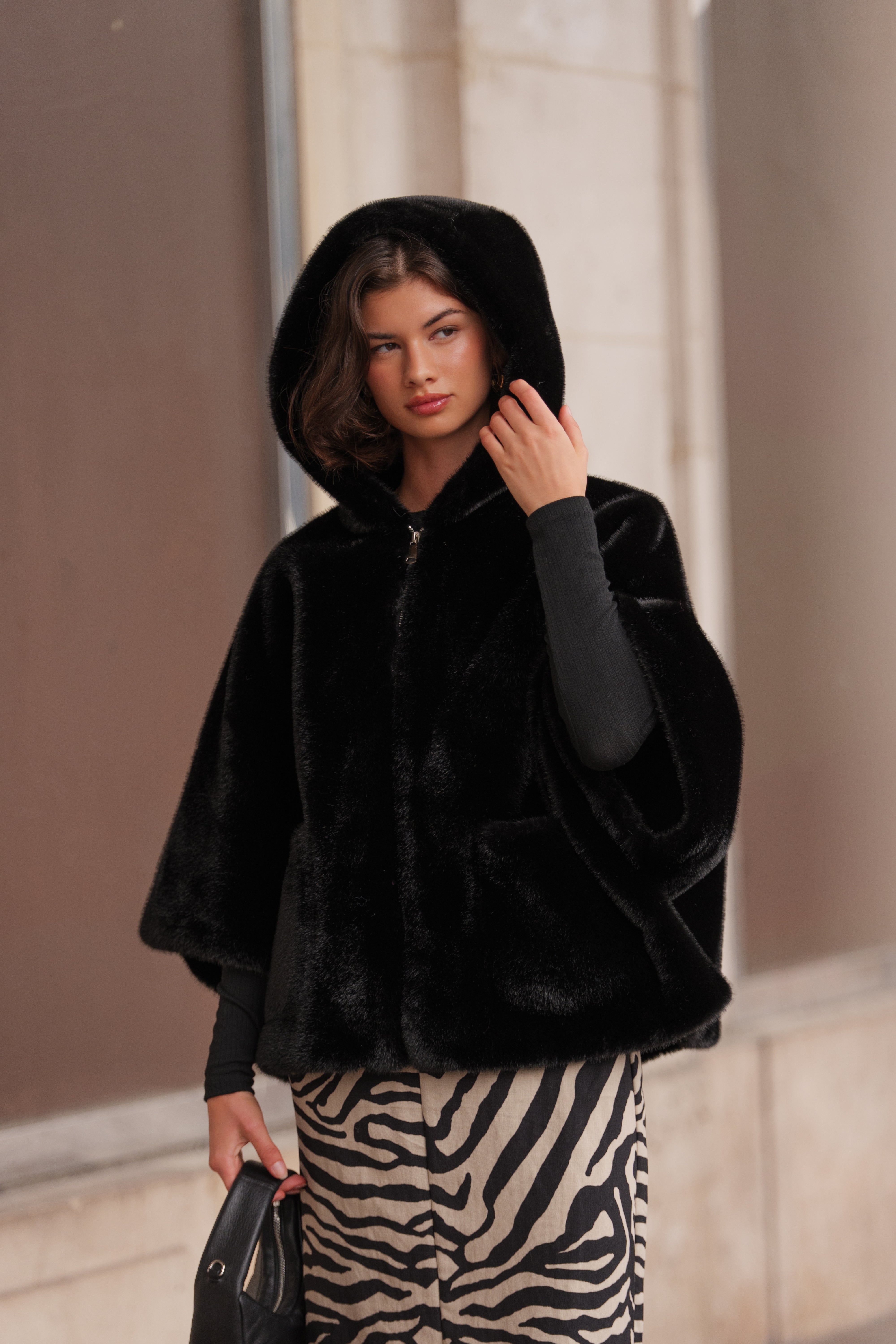Cape en fausse fourrure ROMIE. Coupe ample, capuche enveloppante et poches latérales. Une pièce chaude, chic et confortable.
#couleur_noir