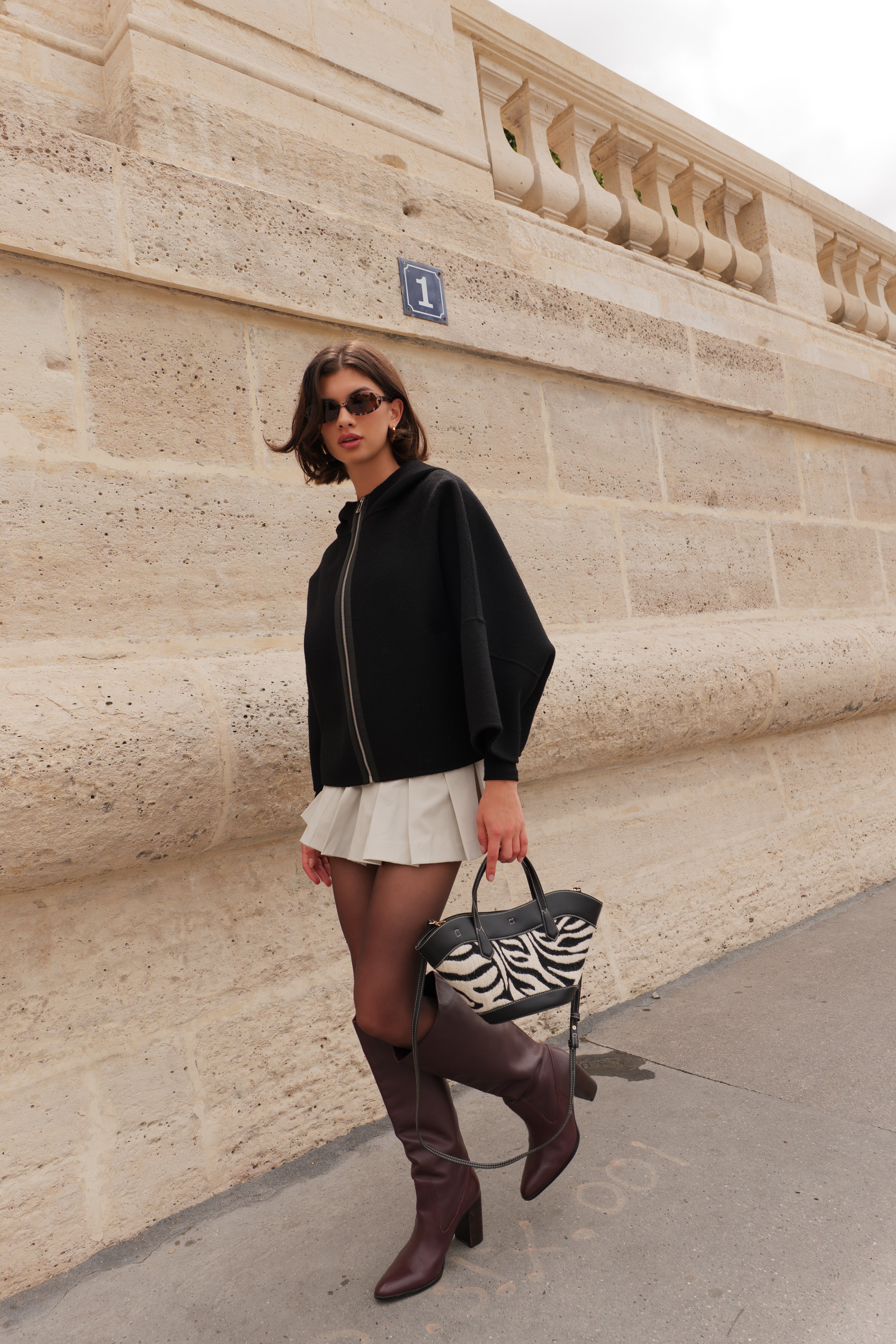 Cape ALAE Escandelle – cape en laine noire portée avec jupe plissée et accessoires modernes
#couleur_noir