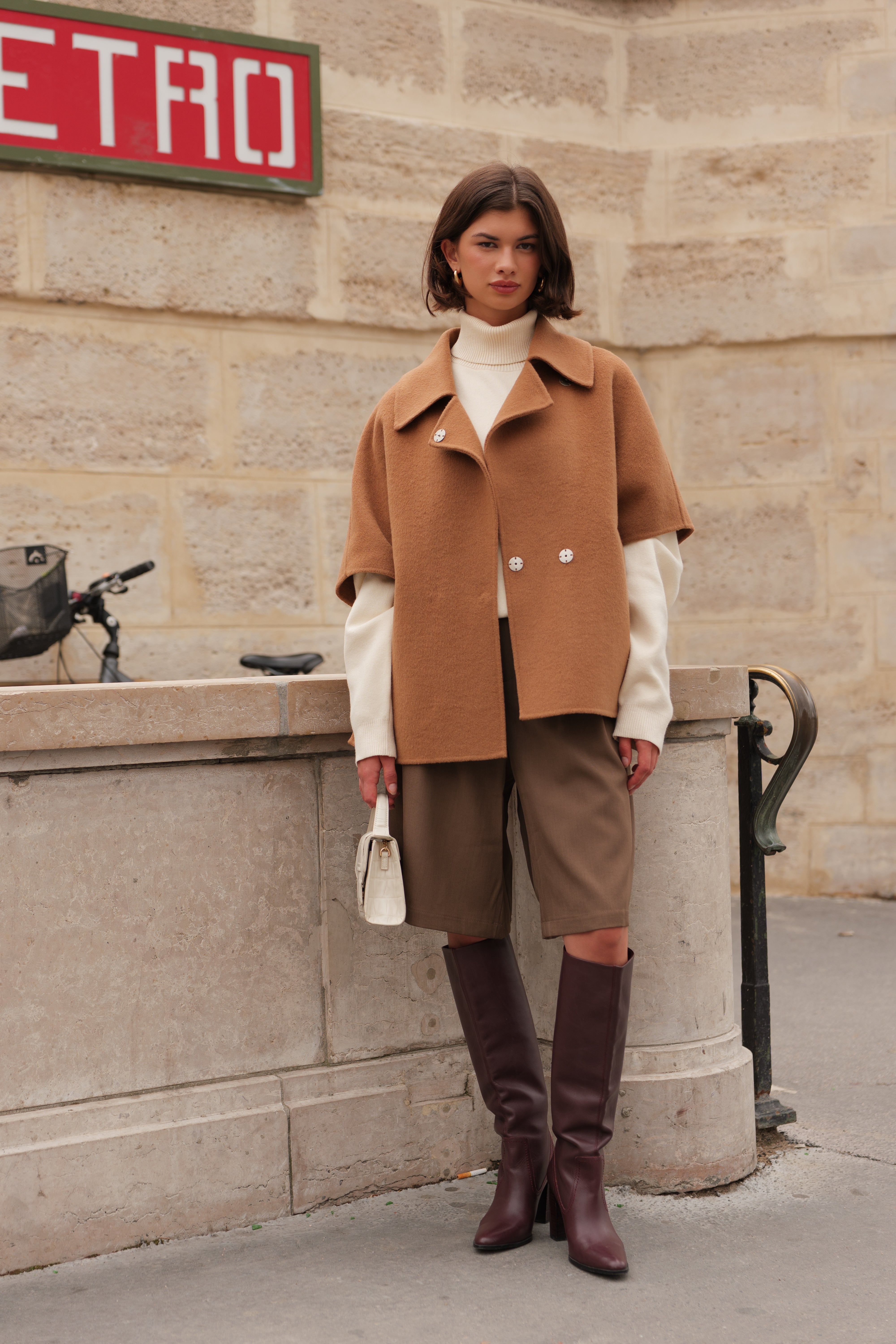 Femme portant la cape AMARA Escandelle en laine camel – vue extérieure – coupe fluide élégante avec col chemise et boutons contrastants
#couleur_camel