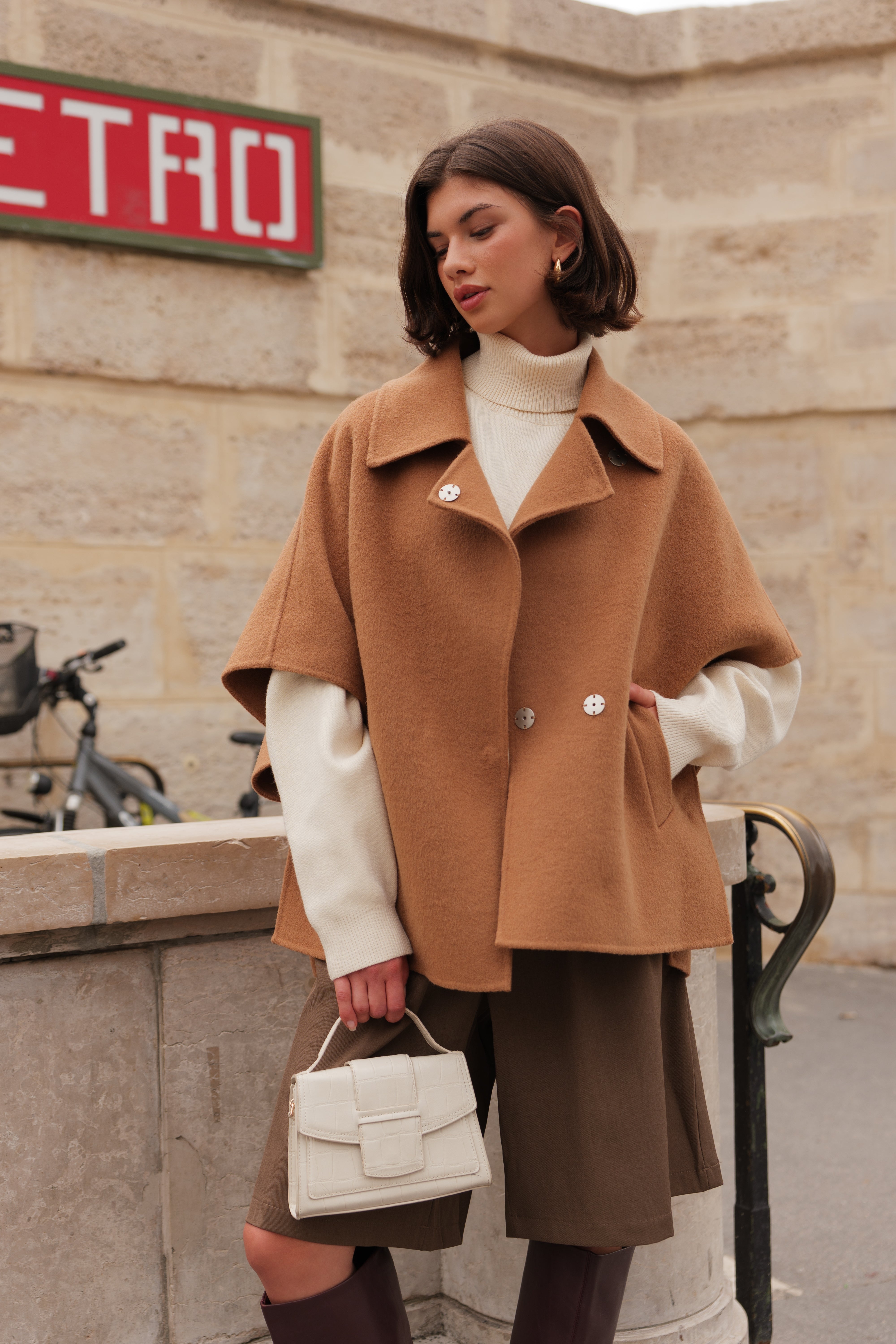 Femme portant la cape AMARA Escandelle en laine camel – vue extérieure – coupe fluide élégante avec col chemise et boutons contrastants
#couleur_camel