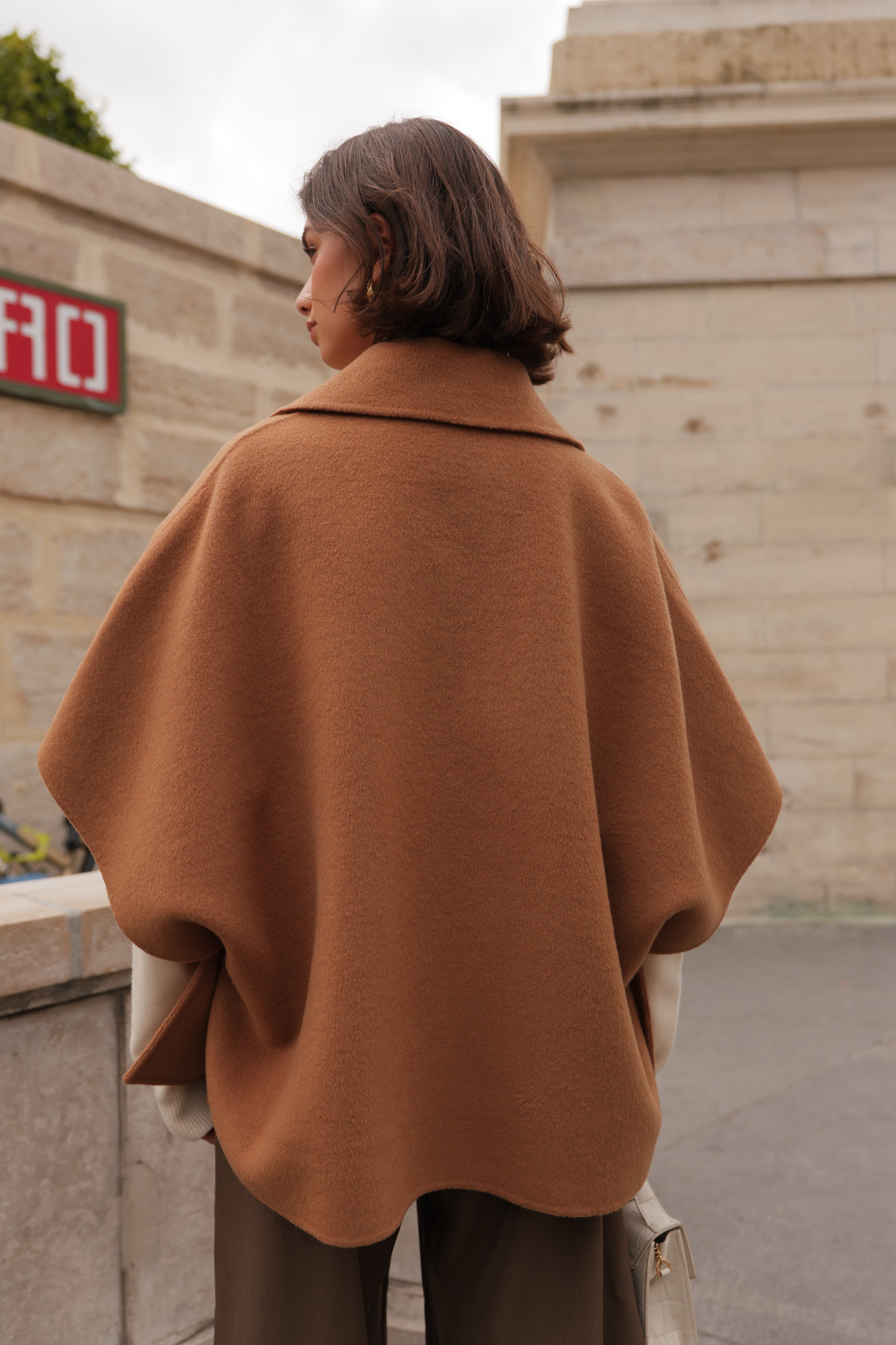 Femme portant la cape AMARA Escandelle en laine camel – vue extérieure – coupe fluide élégante avec col chemise et boutons contrastants
#couleur_camel