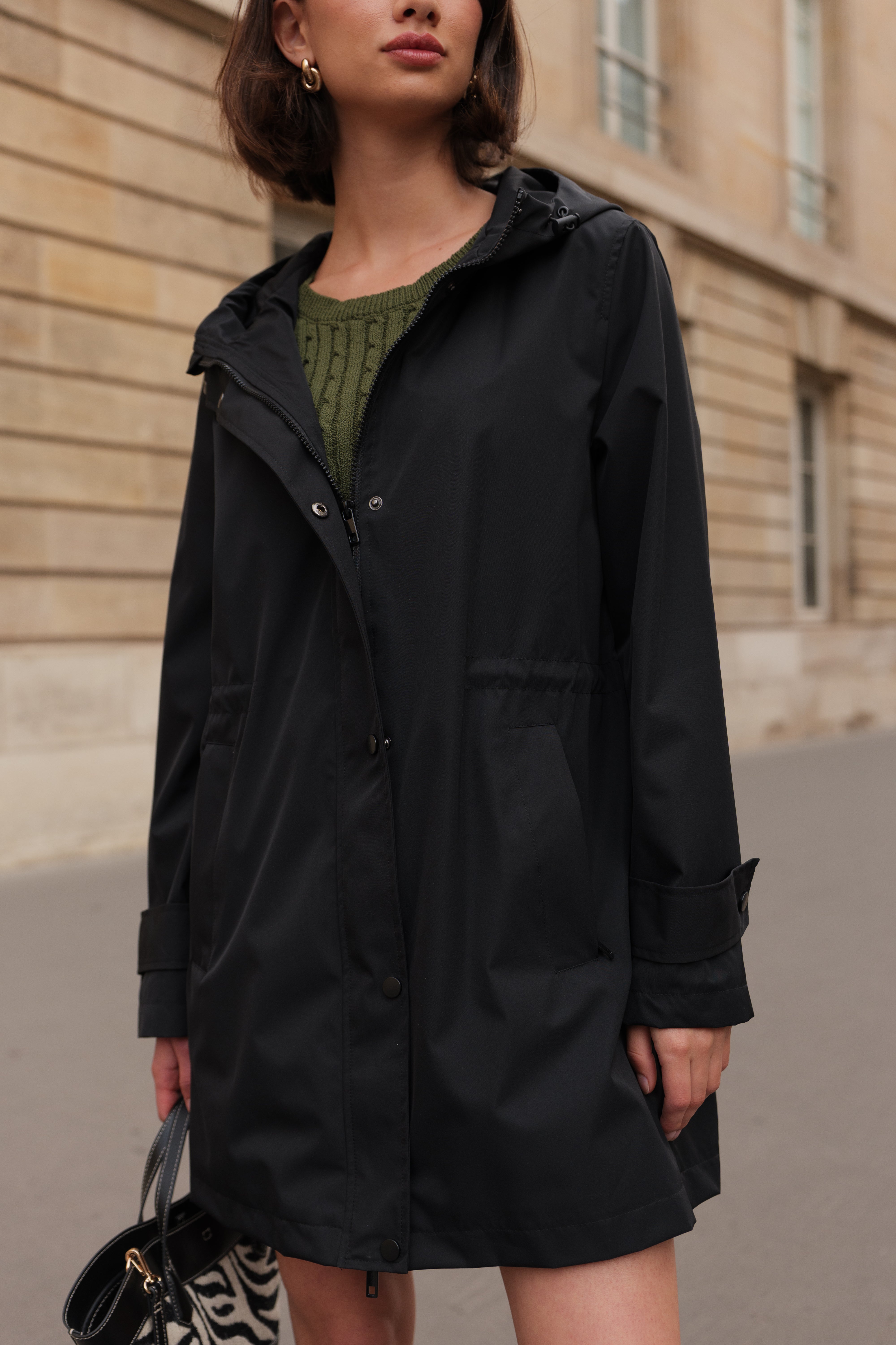 Parka noire LOUANE Escandelle – manteau mi-long déperlant porté avec bottes et pull vert, look automnal élégant.
#couleur_noir