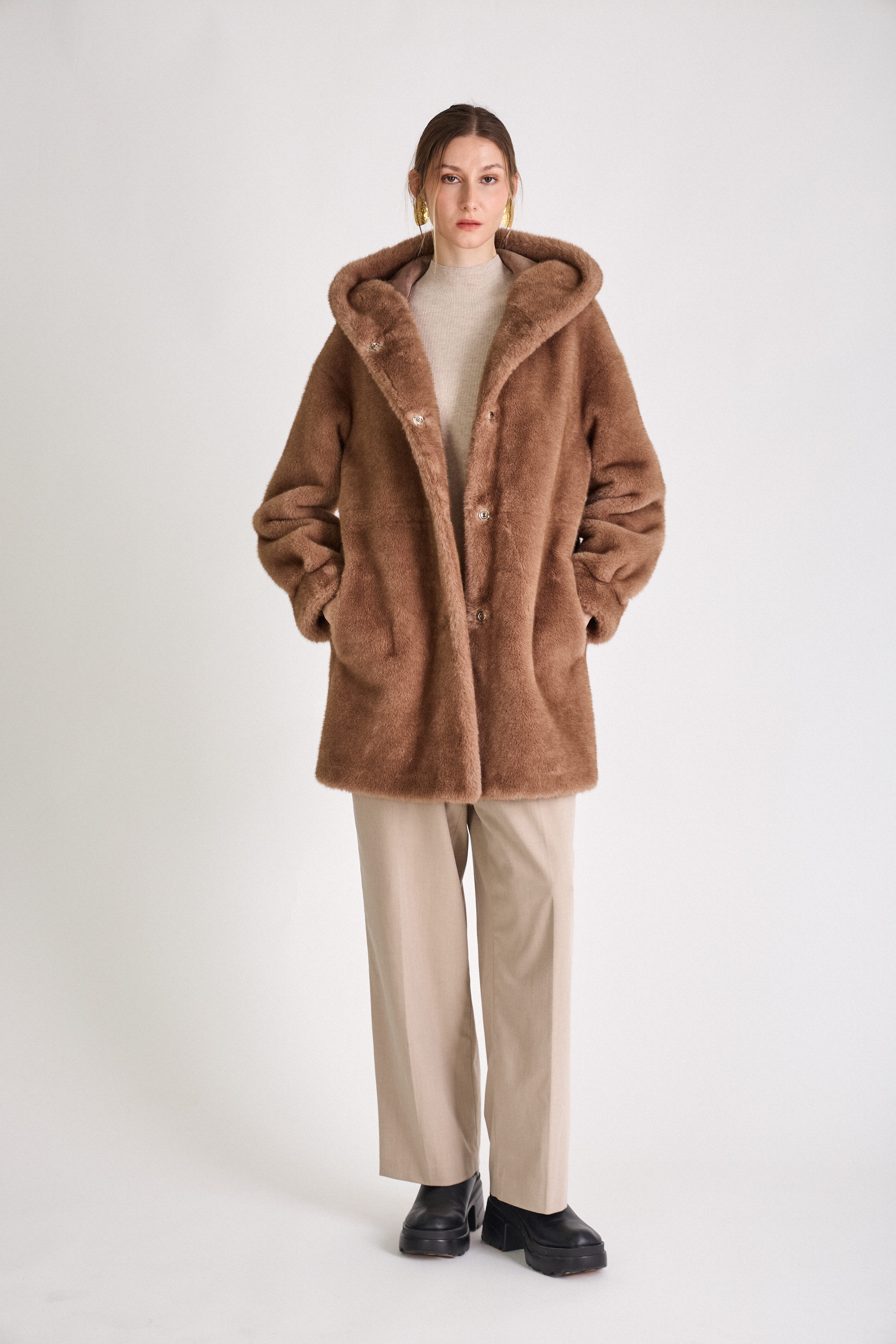 Femme portant le manteau long GRACE en fausse fourrure choco, coupe droite et capuche
#couleur_taupe