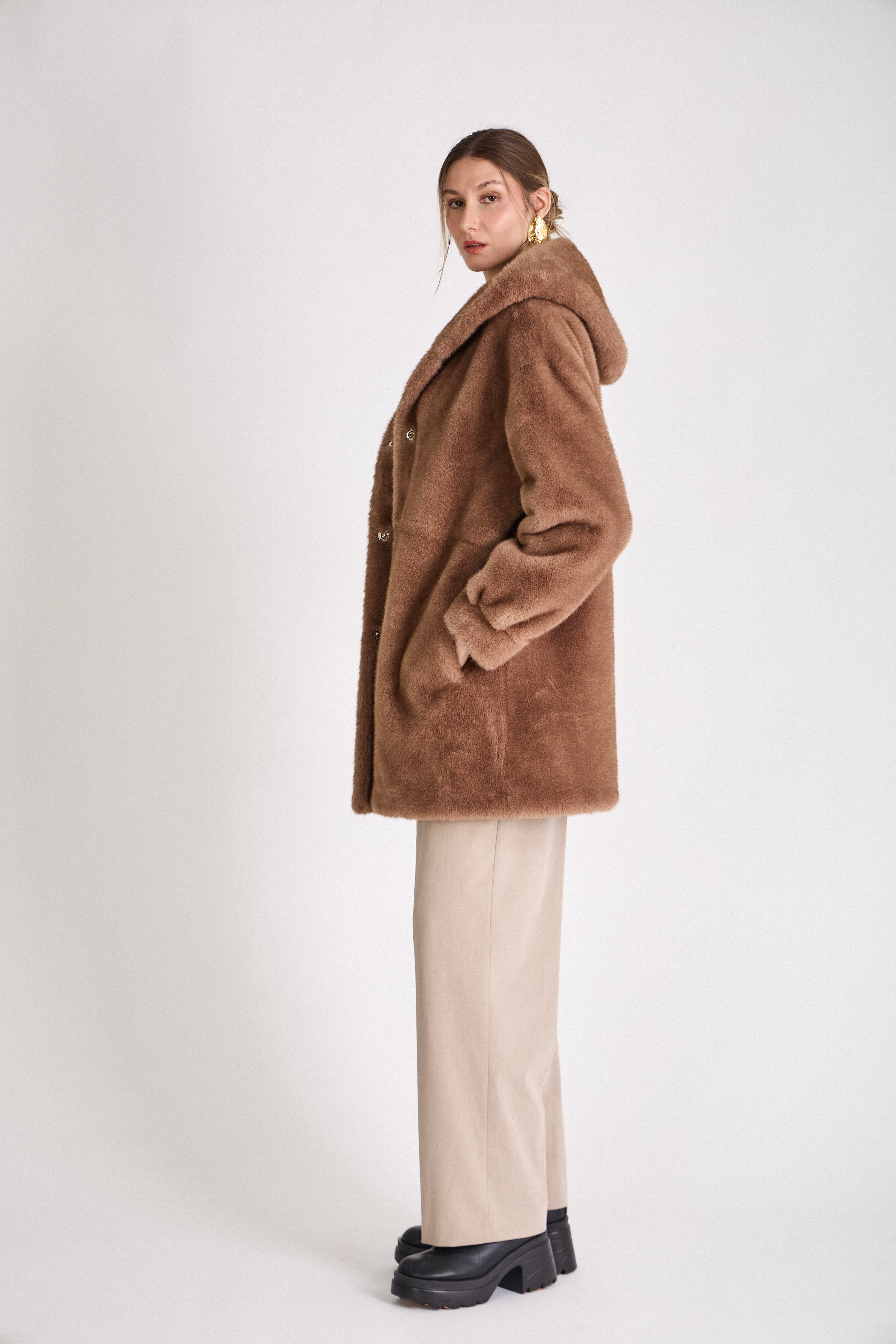 Femme portant le manteau long GRACE en fausse fourrure choco, coupe droite et capuche
#couleur_taupe