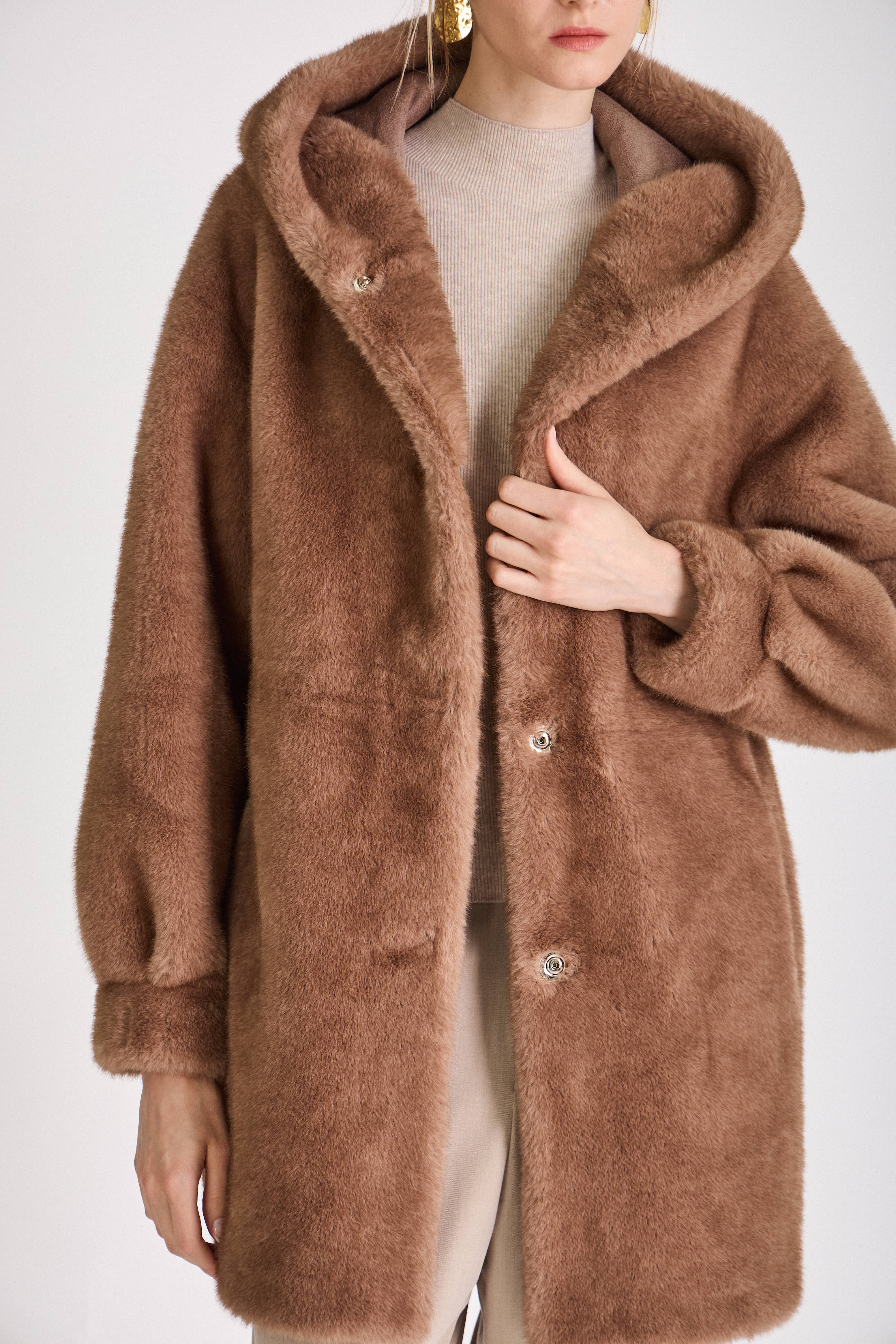 Femme portant le manteau long GRACE en fausse fourrure choco, coupe droite et capuche
#couleur_taupe