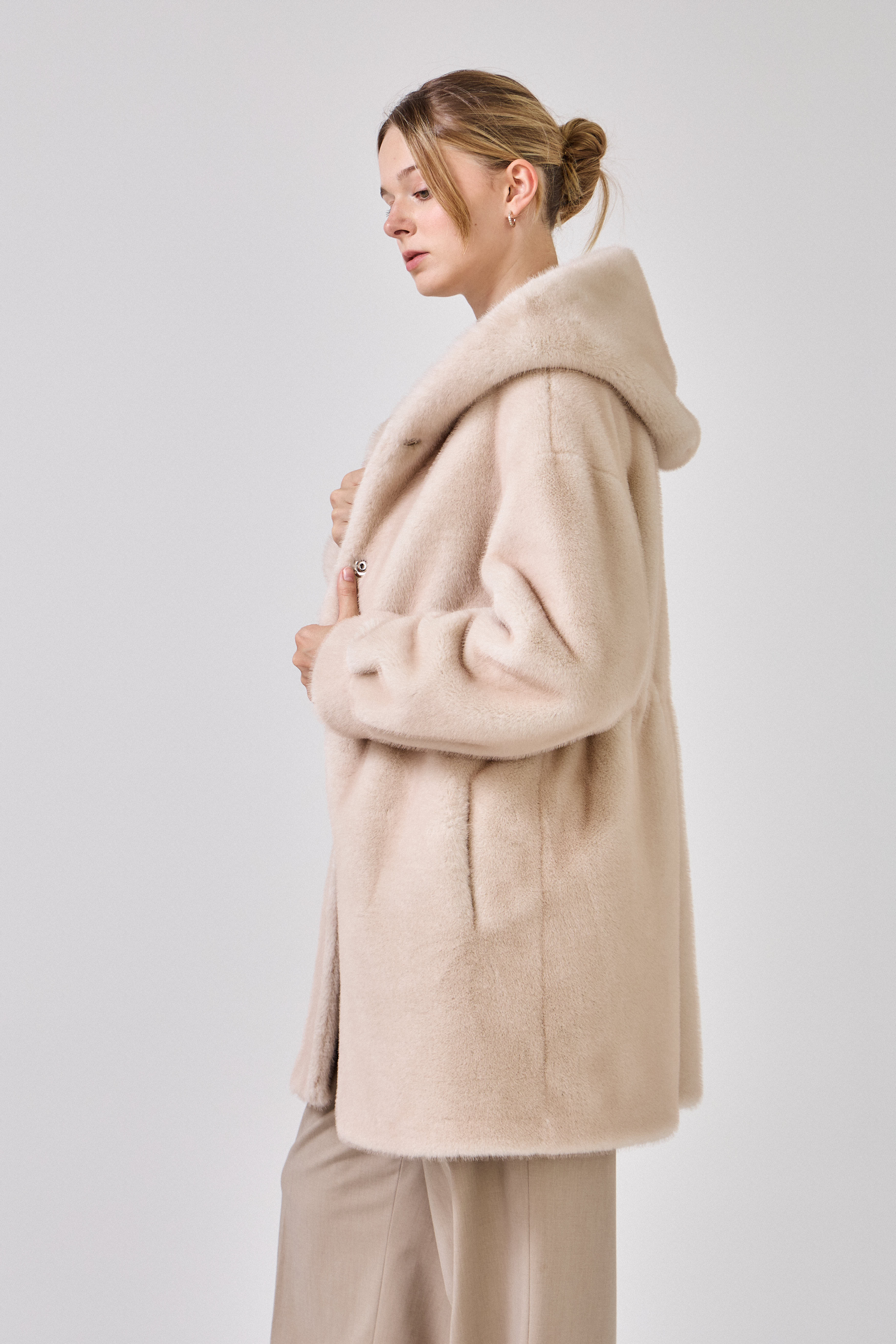 Femme portant le manteau long GRACE en fausse fourrure choco, coupe droite et capuche
#couleur_écru