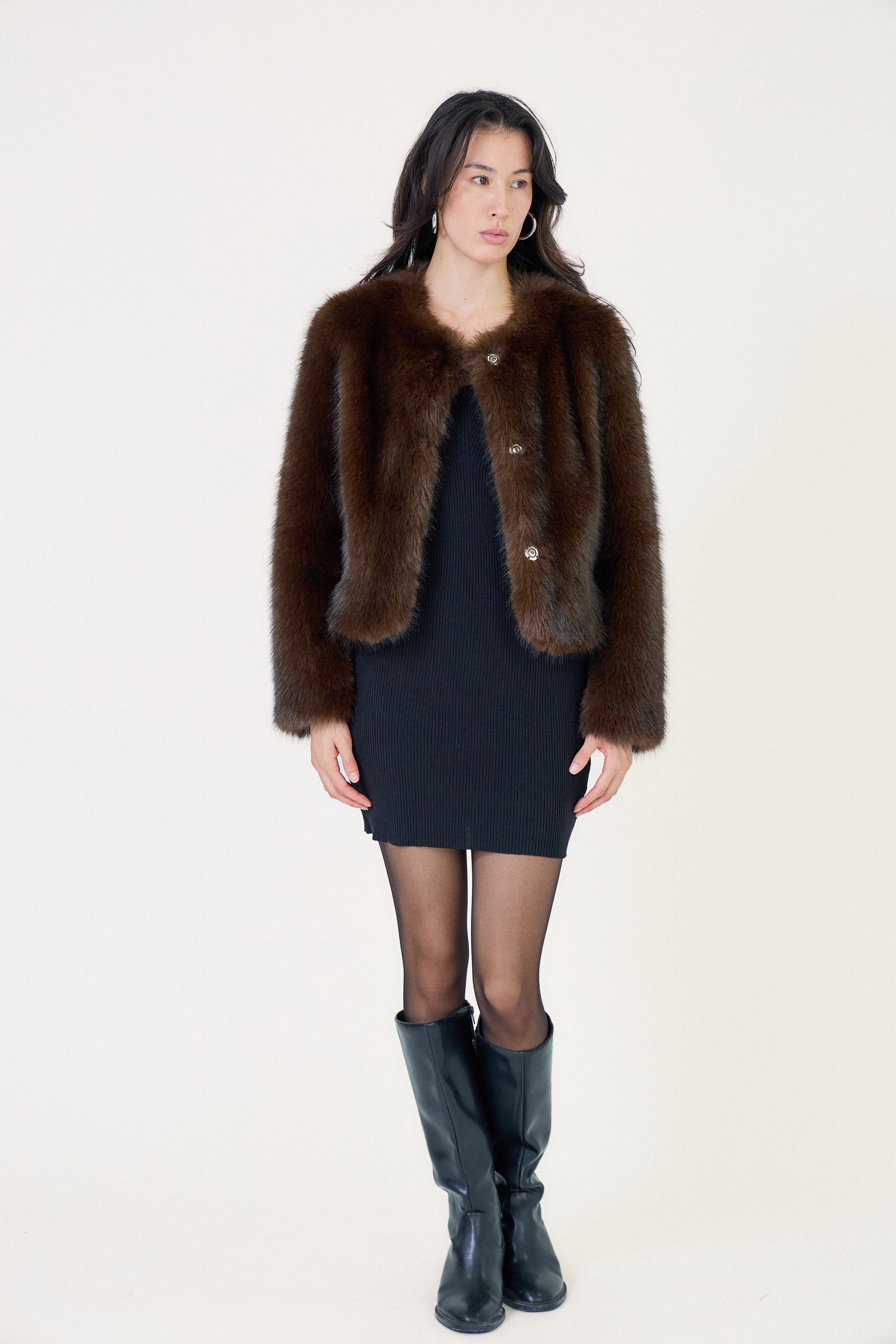 Manteau court en fausse fourrure femme Escandelle Paris, coloris choco, col rond, fermeture à pressions dissimulées, coupe élégante et poils longs doux.
#couleur_choco