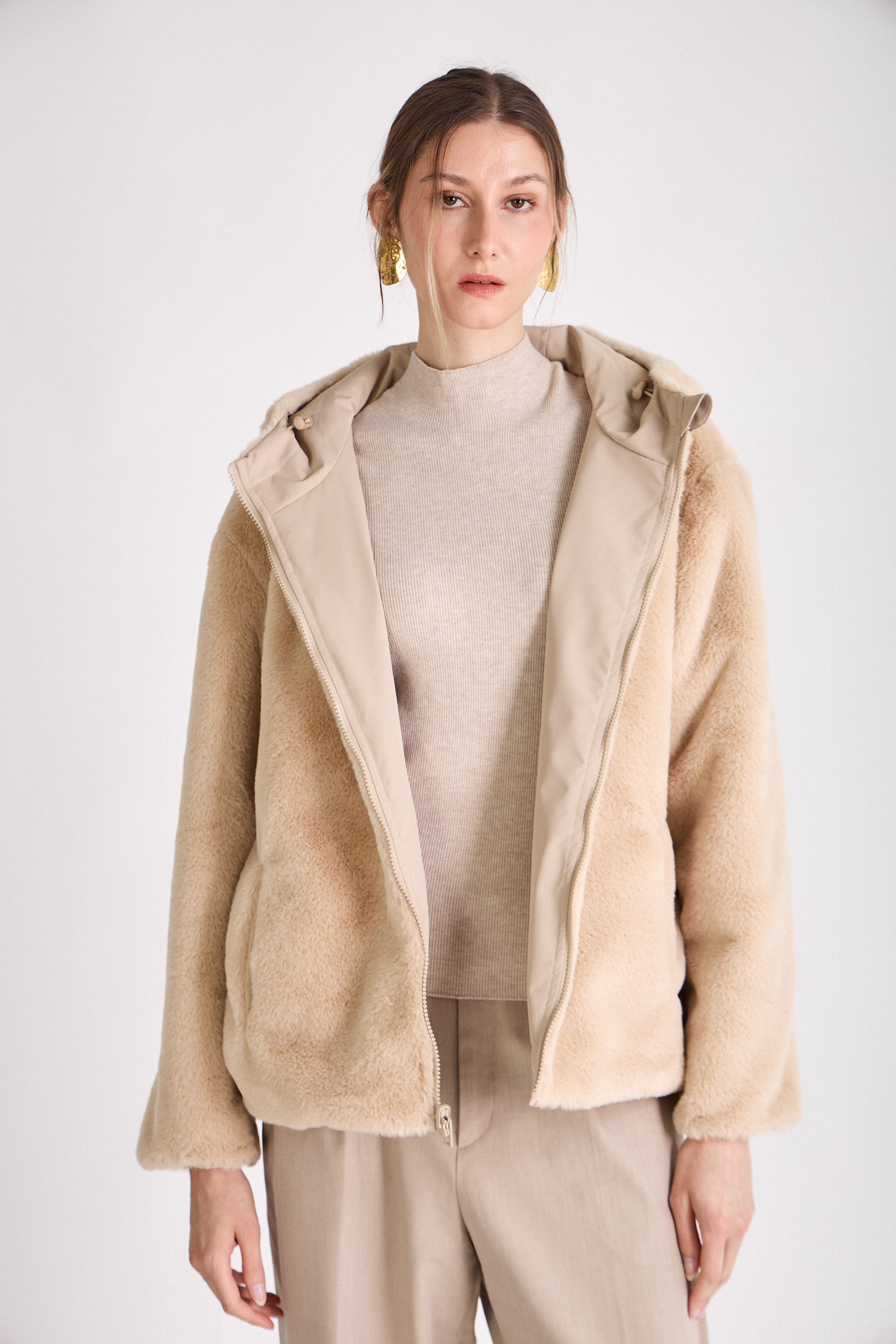 Femme portant une parka beige réversible déperlante à capuche fausse fourrure Escandelle Paris
#couleur_beige